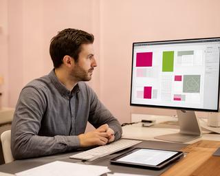 Designer von Limmat Edition GmbH am Arbeitsplatz mit digitalen Journalentwürfen